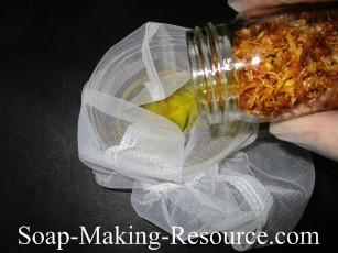 Pouring Calendula Infused Olive Oil through a Filter Pouring Calendula Infused Olive Oil through a Filter