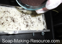 Sprinkling Coffee Grounds onto Top of Soap
