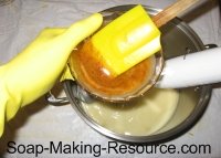 mixing annatto seed powder into soap