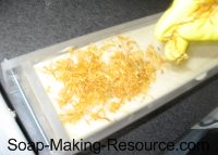 placing calendula petals on top of soap